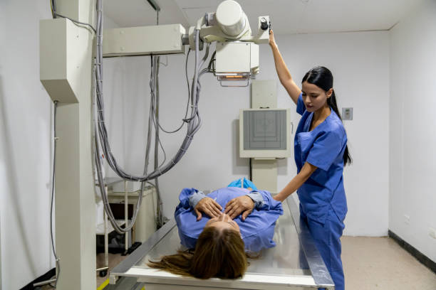 radiólogo tomando una radiografía de una mujer en el hospital - radiologo fotografías e imágenes de stock